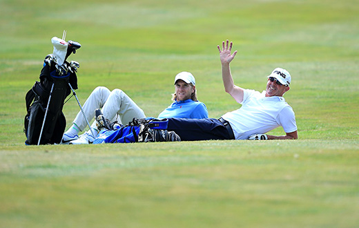 CHESTER, ENGLAND - AUGUST 12:  Gary Hendley of Stepaside Golf Centre(r) and Ben Daniels of Bletchingley GC has a rest during slow play on day one of the Golfbreaks.com PGA Fourball Championship Final at De Vere Carden Park Hotel on August 12, 2015 in Chester, England.  (Photo by Jan Kruger/Getty Images)