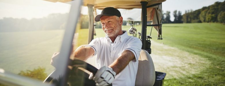 middle aged male driving a golf buggy